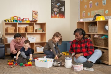 Early Childhood Education students sitting in a room with children, while observing them.